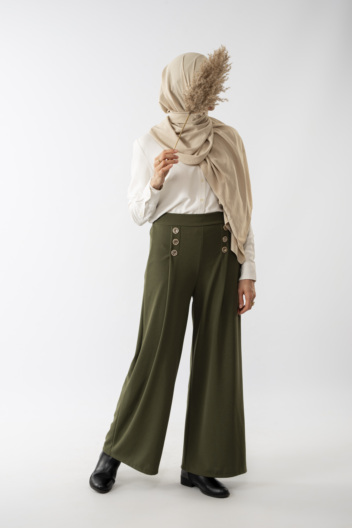 Pantalon Tasnim. Pantalon fluide avec poches et boutons décoratifs. Ce modèle existe en plusieurs coloris. Taille Unique correspond à un 36/40